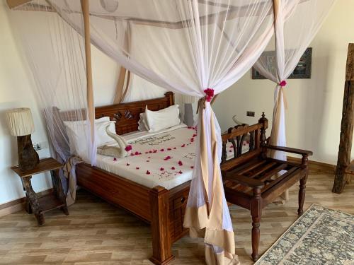 een slaapkamer met een hemelbed bij Zi Villa Garden Room 1 in Matemwe