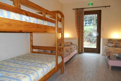 1 dormitorio con 2 literas y ventana en gîte le Ranch de Vassiviére en Royère-de-Vassivière