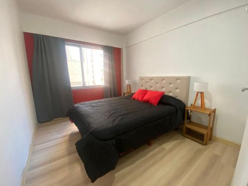 una camera da letto con un cuscino rosso di Departamento en Caballito II a Buenos Aires