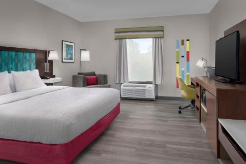 ein Hotelzimmer mit einem Bett und einem Flachbild-TV in der Unterkunft Hampton Inn Birmingham I-65/Lakeshore Drive in Birmingham