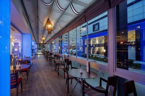 a restaurant with tables and chairs and windows at Hampton By Hilton Gaziantep in Gaziantep