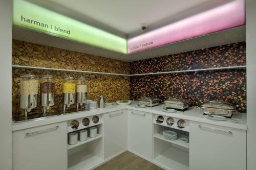 a kitchen with white cabinets and a wall filled with food at Hampton By Hilton Gaziantep in Gaziantep