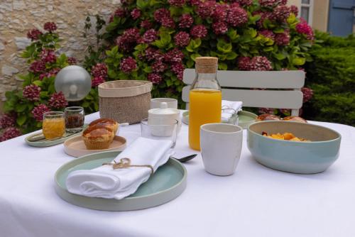 a table with a plate of food and a bottle of orange juice at Le Poutic gîte et maison d'hôtes in Créon-dʼArmagnac
