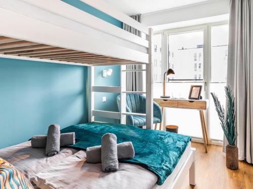 sypialnia z łóżkiem piętrowym i niebieską ścianą w obiekcie FeWo Prora - Baltic Sunset w mieście Binz