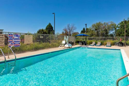 uma piscina com cadeiras e uma cerca em Hampton Inn & Suites Rohnert Park - Sonoma County em Rohnert Park