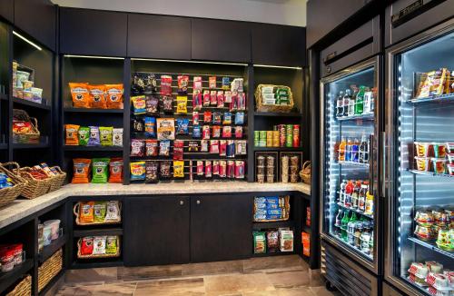 a grocery store refrigerator with lots of food at Embassy Suites by Hilton Orlando International Drive Convention Center in Orlando