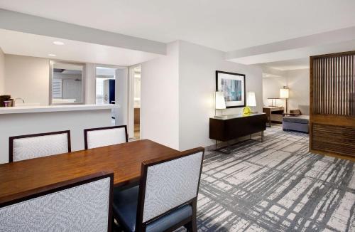a living room with a wooden table and chairs at Embassy Suites by Hilton Orlando International Drive Convention Center in Orlando