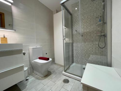 uma casa de banho com um WC e uma cabina de duche em vidro. em BERGANTIN 109 by SOM Menorca em Fornells