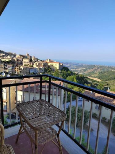 a chair on a balcony with a view of a city at B&B La Finestra Sul Mare in Ripatransone