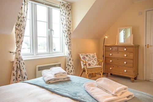 a bedroom with a bed and a window and a dresser at Isis Lakes 40 - Casa Angela in South Cerney