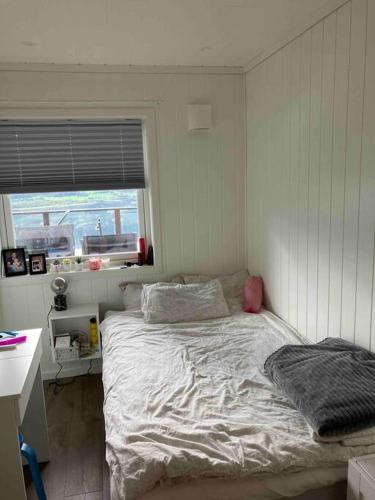 1 dormitorio con cama, ventana y escritorio en Modern family home in Voss en Vossevangen
