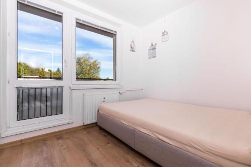1 dormitorio con cama y ventana en Dvojizbový byt blízko centra - 24h self check-in, en Banská Bystrica