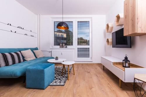 a living room with a blue couch and a table at Netflix & WiFi FREE Dvojizbový byt blízko centra - 24h self check-in in Banská Bystrica