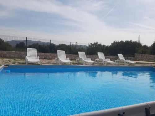 a group of chairs and a swimming pool at Kamping Luke in Trebinje