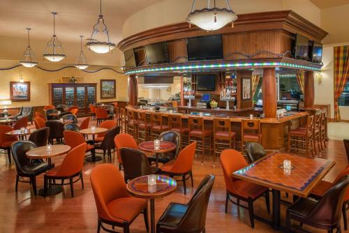 a restaurant with tables and chairs and a bar at Hilton Seattle Airport & Conference Center in SeaTac