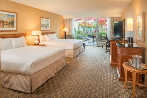 a hotel room with two beds and a television at Hilton Seattle Airport & Conference Center in SeaTac