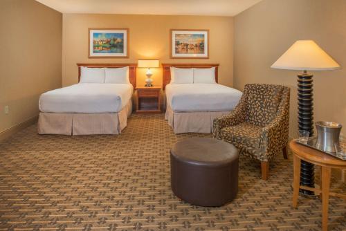 a hotel room with two beds and a chair at Hilton Seattle Airport & Conference Center in SeaTac