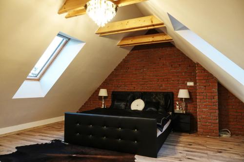 a loft conversion with a brick wall and a couch at Vila na Spině in Vsetín