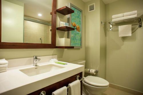 a bathroom with a sink and a toilet and a mirror at Hampton Inn by Hilton Merida in Mérida