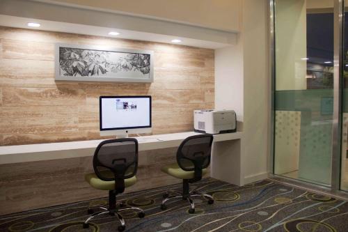 an office with two chairs and a computer on a desk at Hampton Inn by Hilton Merida in Mérida