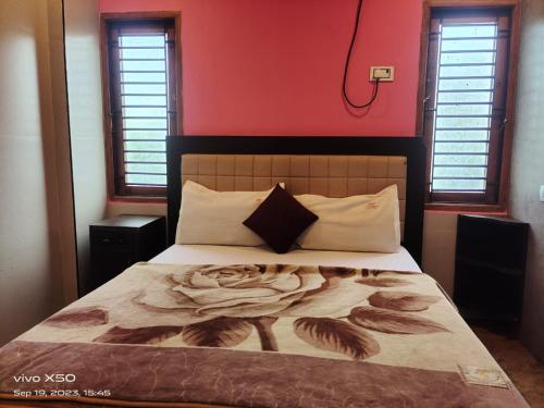 een slaapkamer met een groot bed met een rode muur bij CAUVERY PARADISE in Mayiladuthurai