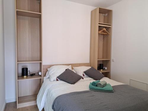 a bedroom with a bed with a green towel on it at Appartement proche plage hendaye in Hendaye