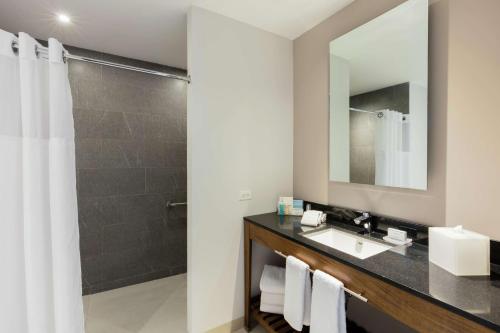 a bathroom with a sink and a shower at Hampton Inn By Hilton Cancun Cumbres in Cancún