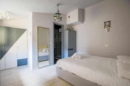 una camera da letto bianca con un letto e uno specchio di Viale 24 a Trieste
