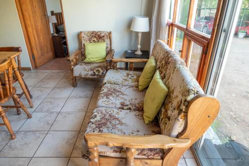 a living room with a couch and two chairs at De Rusty Farm in De Rust