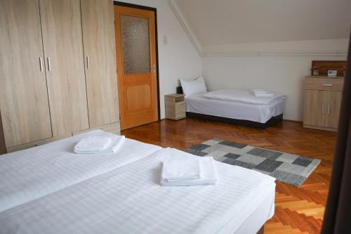 a living room with two beds and a door at Madison Vendégház 2 in Kisvárda