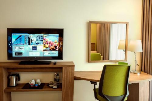 a room with a television on a desk with a chair at Hampton By Hilton Kalisz in Kalisz