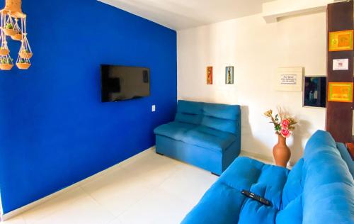 uma sala de estar azul com um sofá azul e uma televisão em Hotel Malibu em Porto Seguro