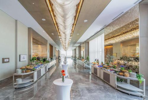 a lobby with tables with flowers on them at Hilton Abu Dhabi Yas Island in Abu Dhabi