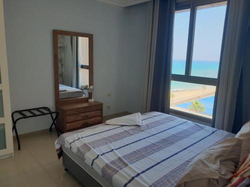 een slaapkamer met een bed en uitzicht op het strand bij beach Apartments in Haifa