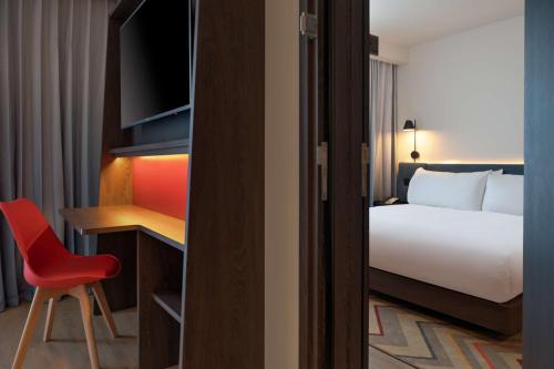 a hotel room with a bed and a desk and a chair at Hampton by Hilton Ashford International in Ashford