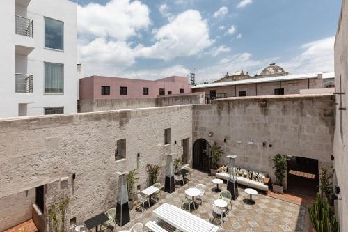 an outdoor patio with tables and chairs next to a brick building at Hampton by Hilton Arequipa in Arequipa