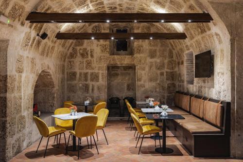 a restaurant with tables and chairs in a stone room at Hampton by Hilton Arequipa in Arequipa