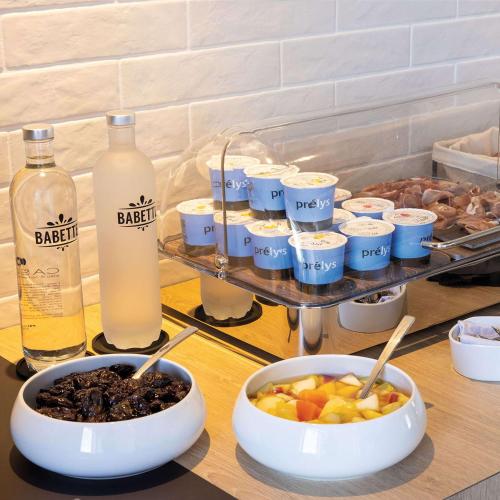 トゥールにあるHilton Garden Inn Tours Centre, Franceの食べ物の入ったボウルと牛乳の瓶が置かれたテーブル