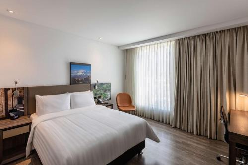 a hotel room with a bed and a desk and a window at Hampton by Hilton Arequipa in Arequipa