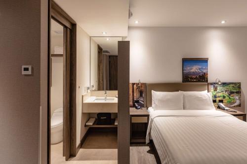 a bathroom with a bed and a sink in a room at Hampton by Hilton Arequipa in Arequipa