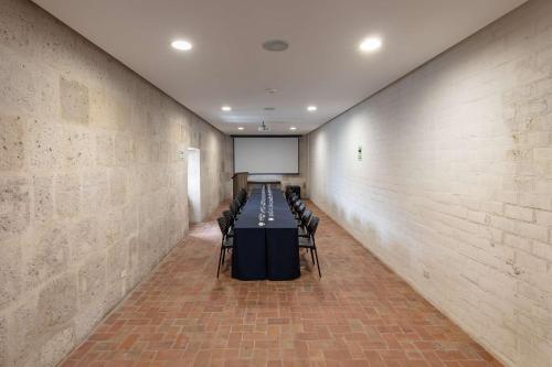 a room with a table with chairs and a screen at Hampton by Hilton Arequipa in Arequipa
