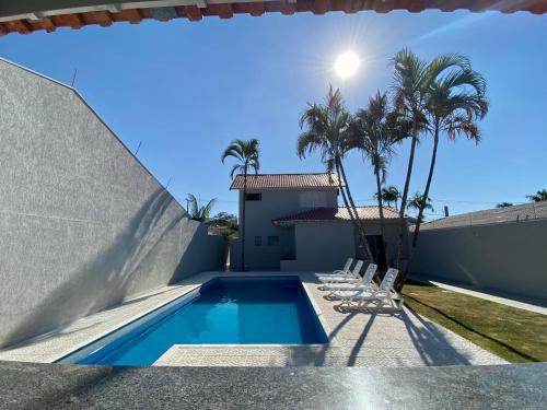 uma villa com piscina e palmeiras em Linda Casa com Piscina em Marília