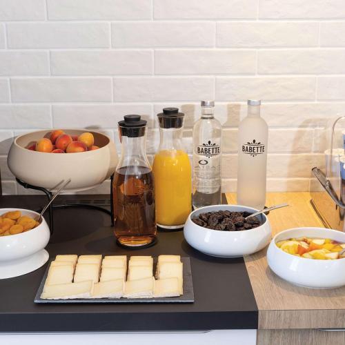 トゥールにあるHilton Garden Inn Tours Centre, Franceのカウンターの上にチーズと他の材料が載ったまな板