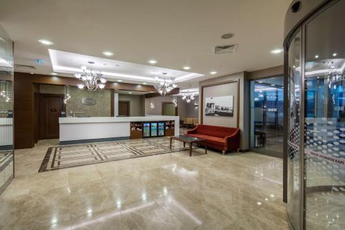 a lobby with a red couch in a building at Hampton by Hilton Canakkale Gelibolu in Gelibolu