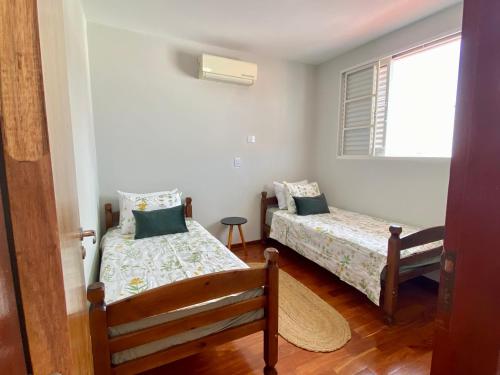 um quarto com 2 camas e uma janela em Linda Casa com Piscina em Marília