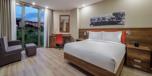 a bedroom with a bed and a desk and a chair at Hampton by Hilton Canakkale Gelibolu in Gelibolu