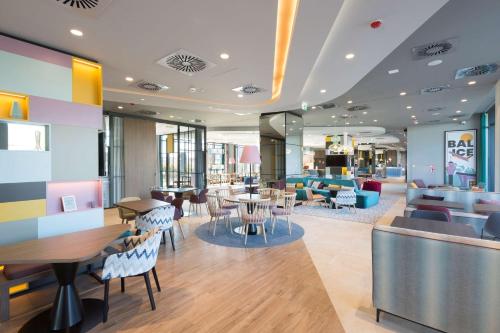 een restaurant met tafels en stoelen in een gebouw bij Hampton by Hilton Krakow Airport in Balice