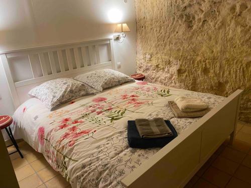 a bedroom with a bed with a blanket and pillows at Gîte troglodyte 2 personnes in Azay-le-Rideau