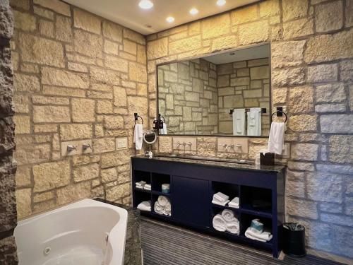 ein Badezimmer mit einem Waschbecken und einem großen Spiegel in der Unterkunft The Oread Lawrence, Tapestry Collection by Hilton in Lawrence