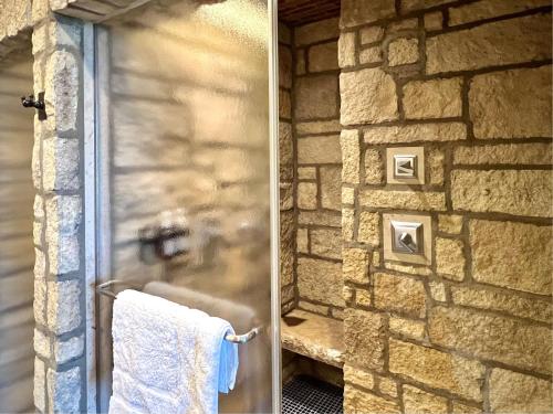 two pictures of a bathroom with a stone wall at The Oread Lawrence, Tapestry Collection by Hilton in Lawrence